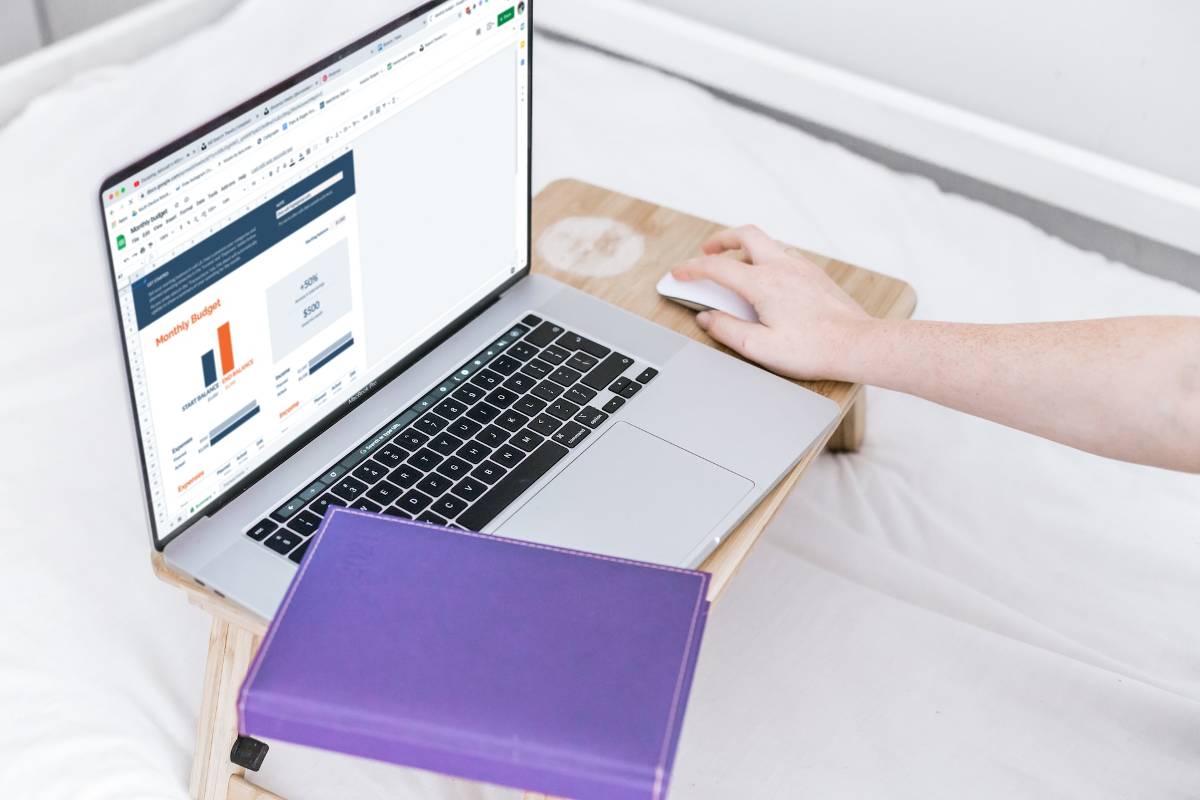 5 Ways to Stay Confident in Retirement 1 Person working on a budget spreadsheet on a laptop, a purple notebook beside it