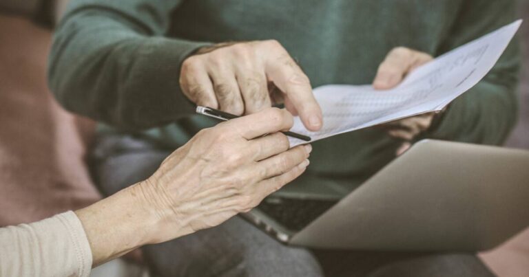 Home 17 Older adult reviewing an estate planning document with an advisor over a laptop