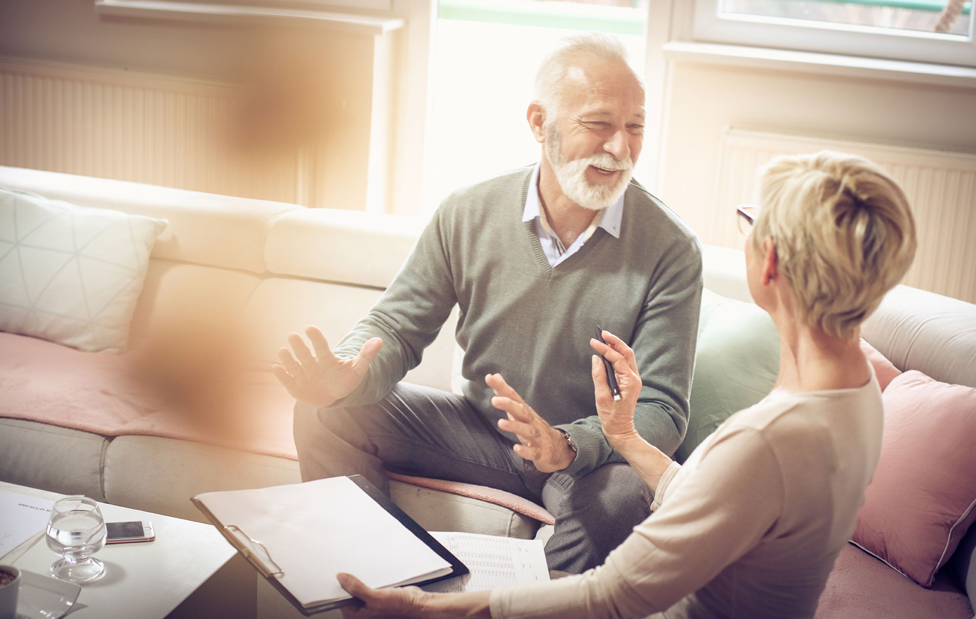 Estate Strategies: Critical Elements of an Estate Plan 1 Older couple talking with an adviser over documents on a sofa