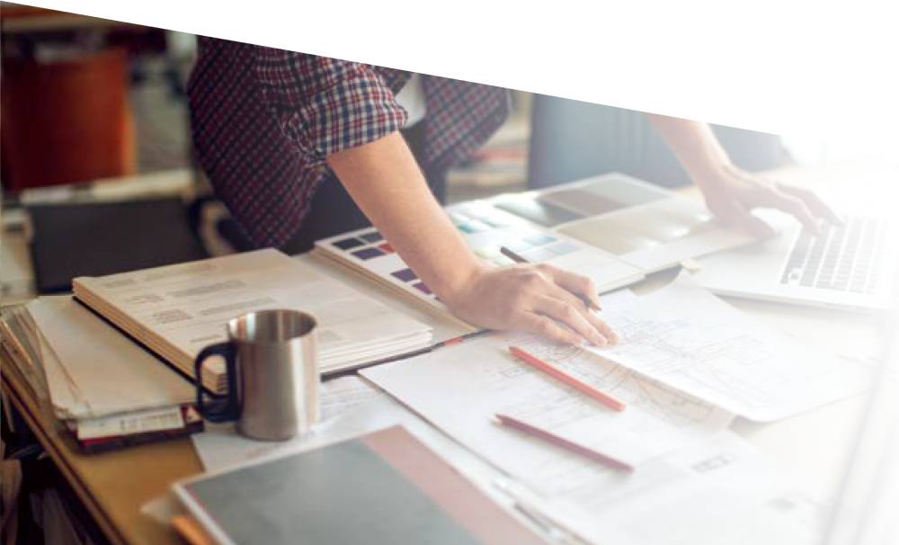 5 Retirement Mistakes Small-Business Owners Make (And How to Avoid Them) 2 Man at a desk reviewing paperwork beside a laptop and coffee