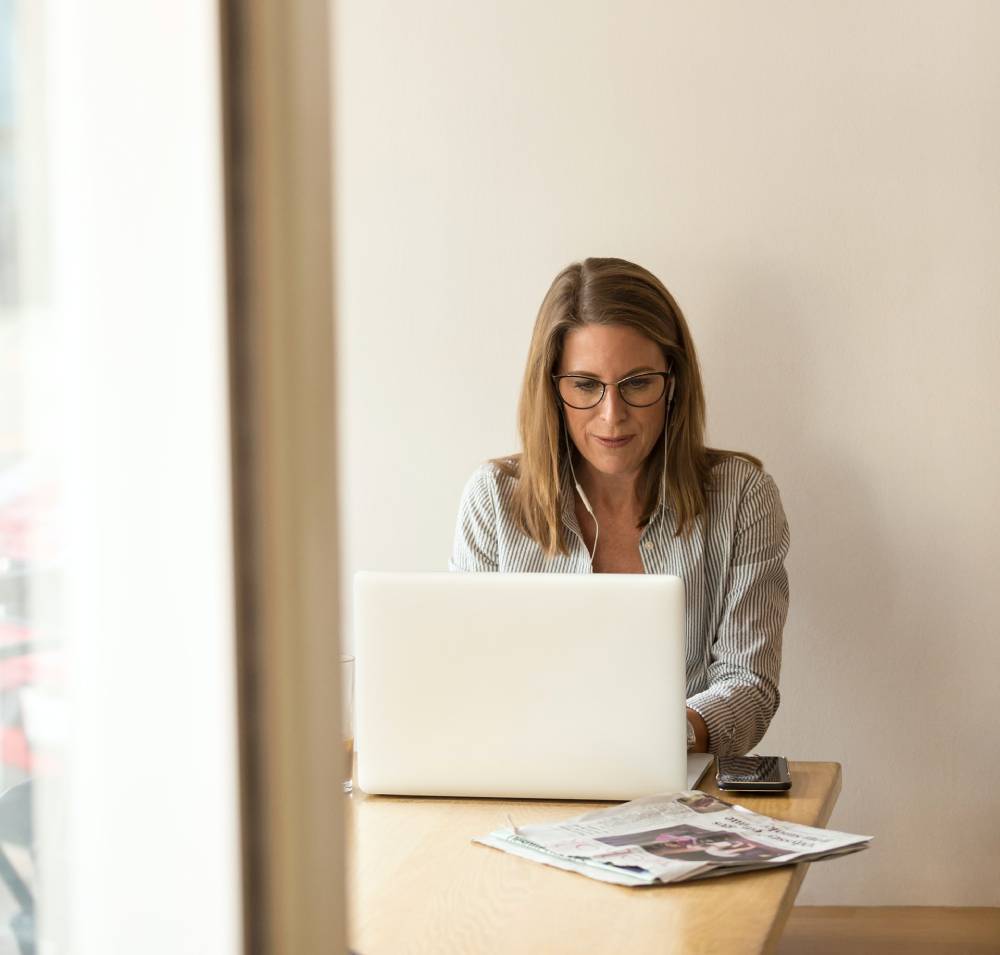 5 Ways to Stay Confident in Retirement 6 Woman with glasses working at a laptop by a sunlit window